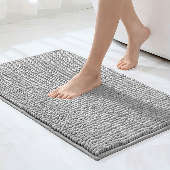 Chenille bath mat with a non-slip backing on a bathroom floor - product photo 1