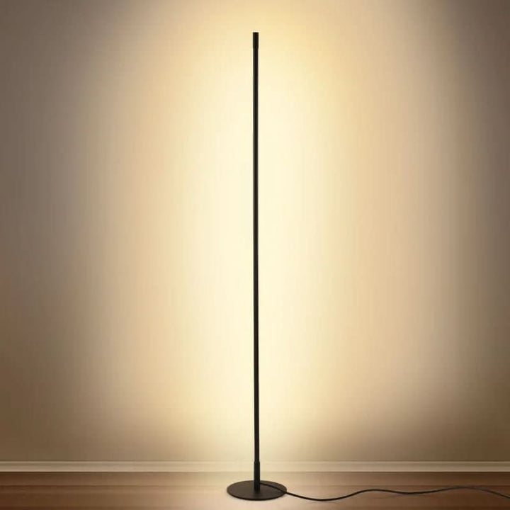 Slim metal LED floor lamp beside a reading chair - product photo 2