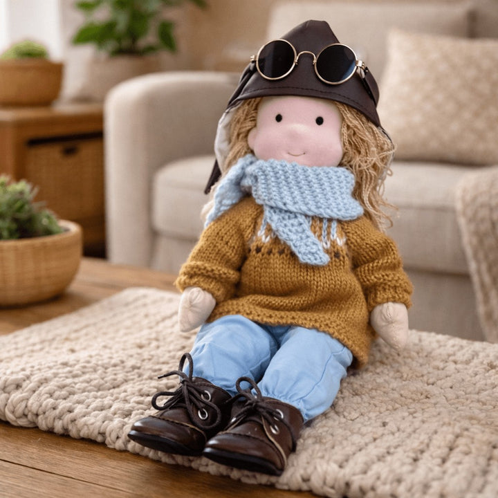 Handmade Waldorf-style cotton doll with an aviator cap with goggles, a mustard sweater, blue pants and lace-up boots