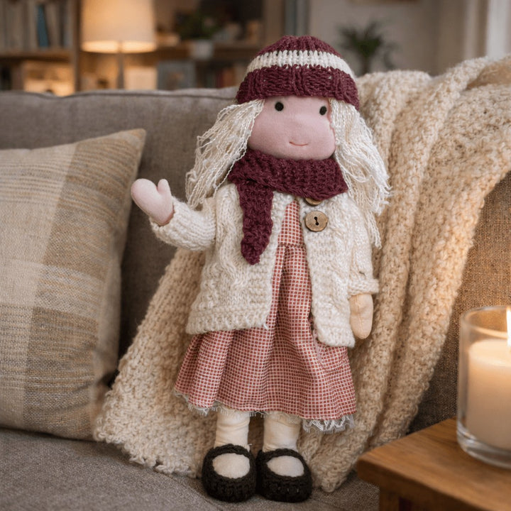 Handmade Waldorf-style cotton doll with a burgundy headband and scarf, cream cardigan and a red gingham skirt