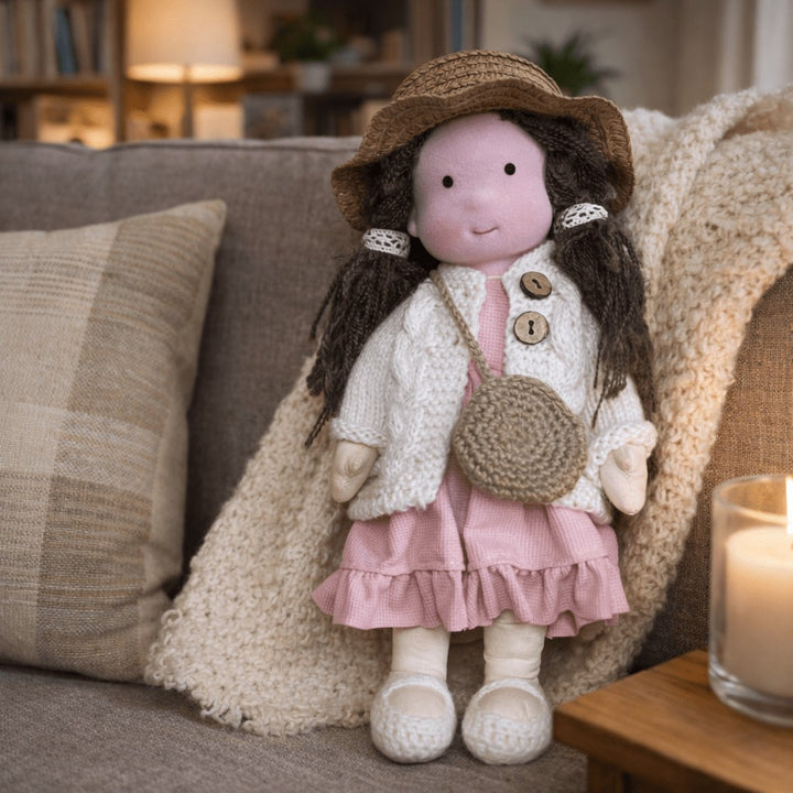 Handmade Waldorf-style cotton doll with a wide-brim hat, cream cardigan, pink ruffle skirt and a round shoulder bag