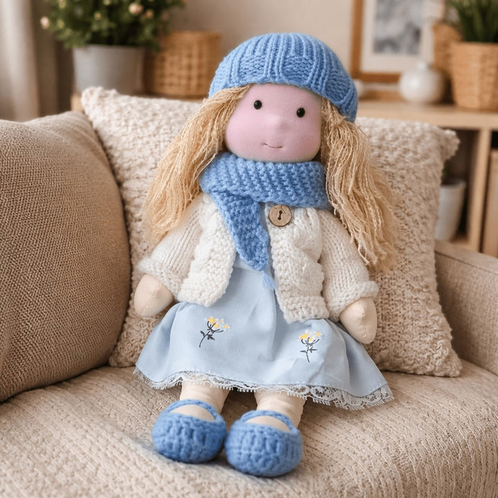Handmade Waldorf-style cotton doll with a blue knit beret and scarf and a blue floral dress