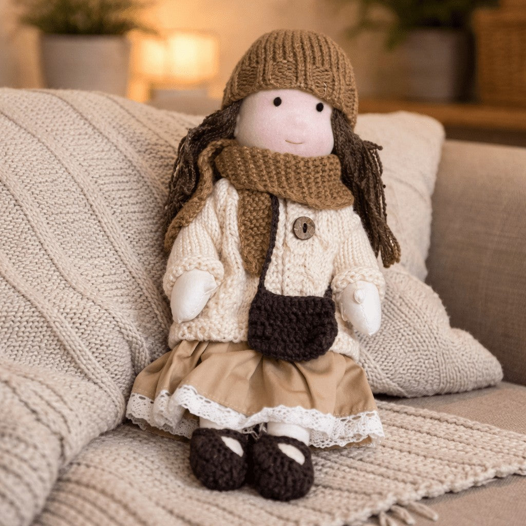 Handmade Waldorf-style cotton doll with a brown knit hat and scarf, cream cardigan, tan skirt and a shoulder bag