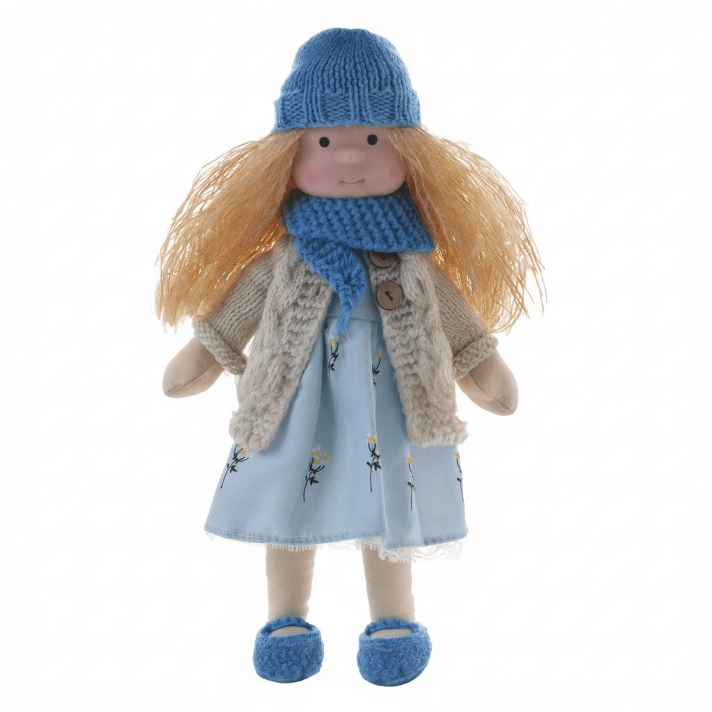 Handmade Waldorf-style cotton doll with a blue knit hat and scarf, gray cardigan and a pale blue dress on white