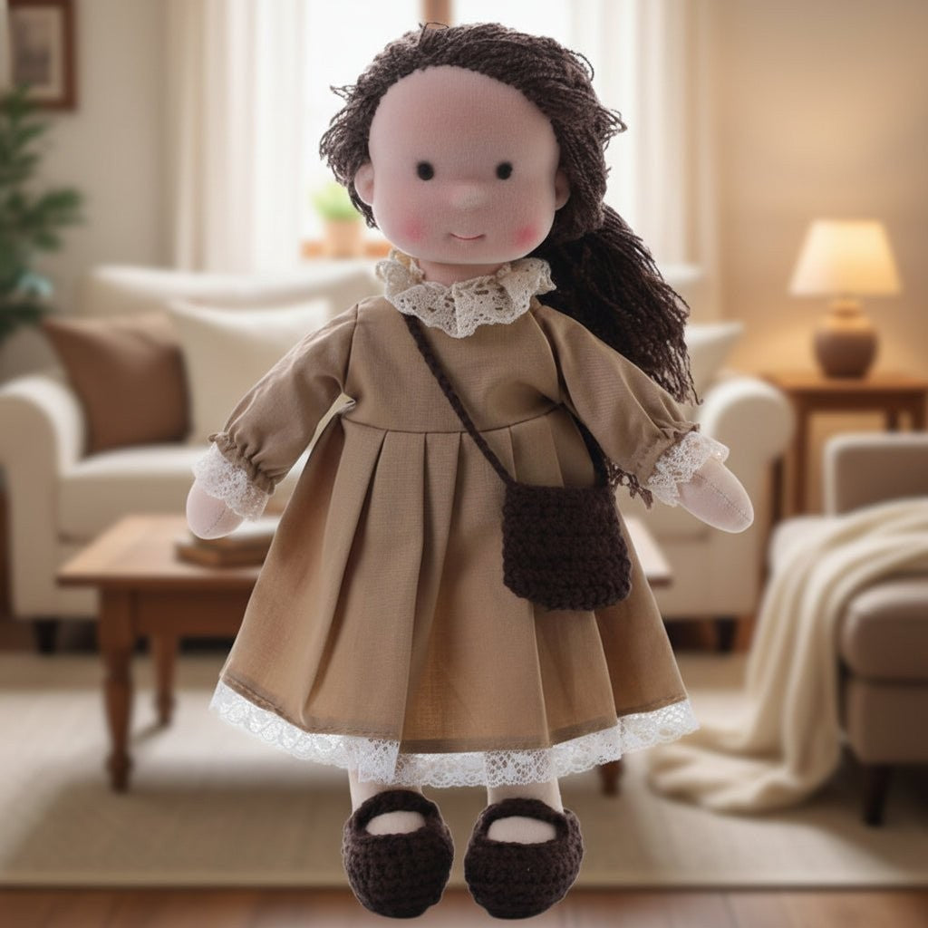 Handmade Waldorf-style cotton doll with dark hair, a tan dress with a lace collar and a shoulder bag