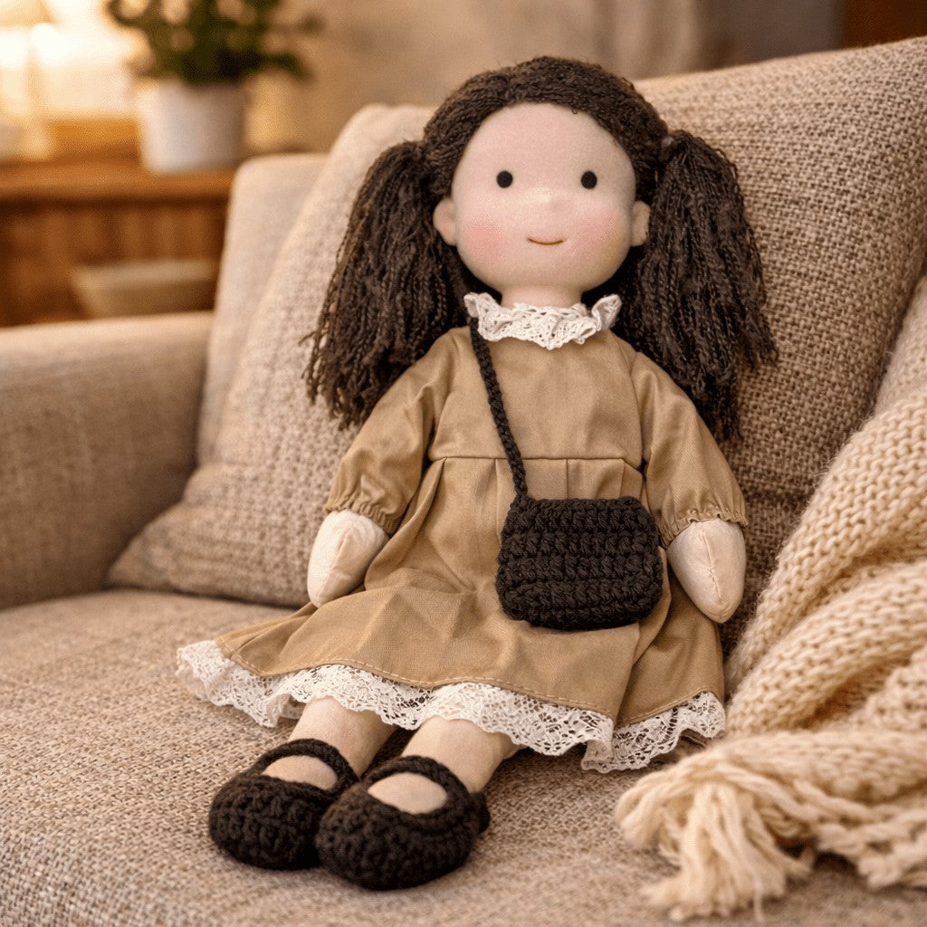Handmade Waldorf-style cotton doll with brown pigtails, a tan lace-trimmed dress and a small shoulder bag