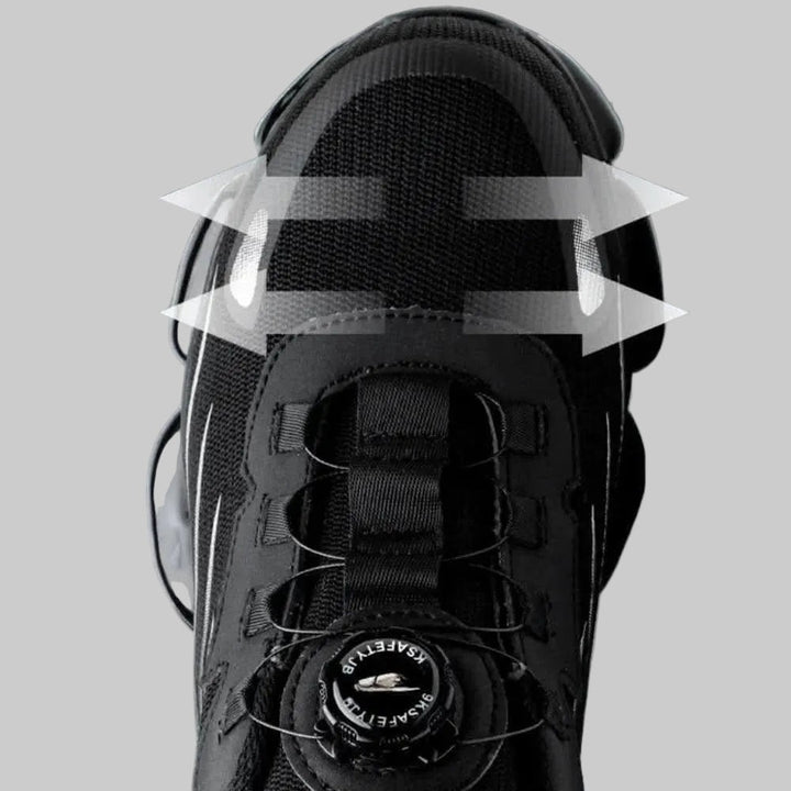 Close-up of the twist-dial lacing system and steel wire guides on a black work shoe