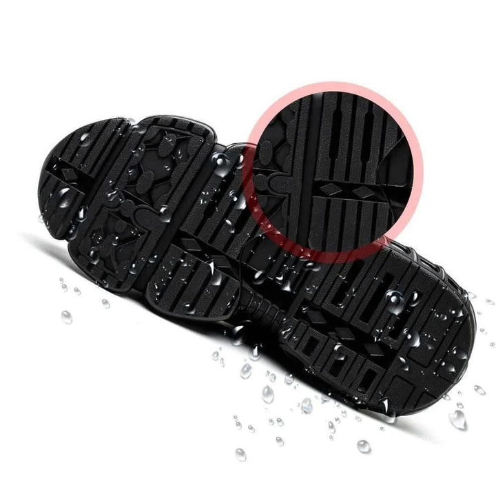 Underside of a work sneaker showing the deep slip-resistant tread with water droplets